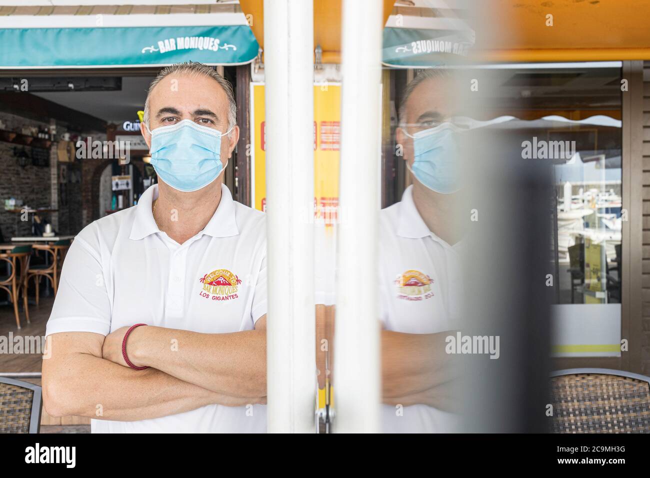 Bar owner wearing face mask at Moniques bar, in the aftermath of the