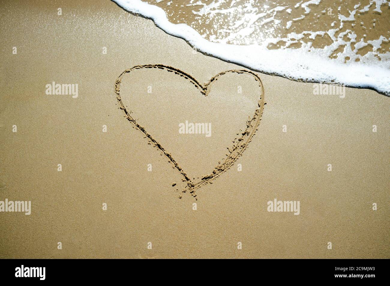 Drawn heart in the sand Stock Photo