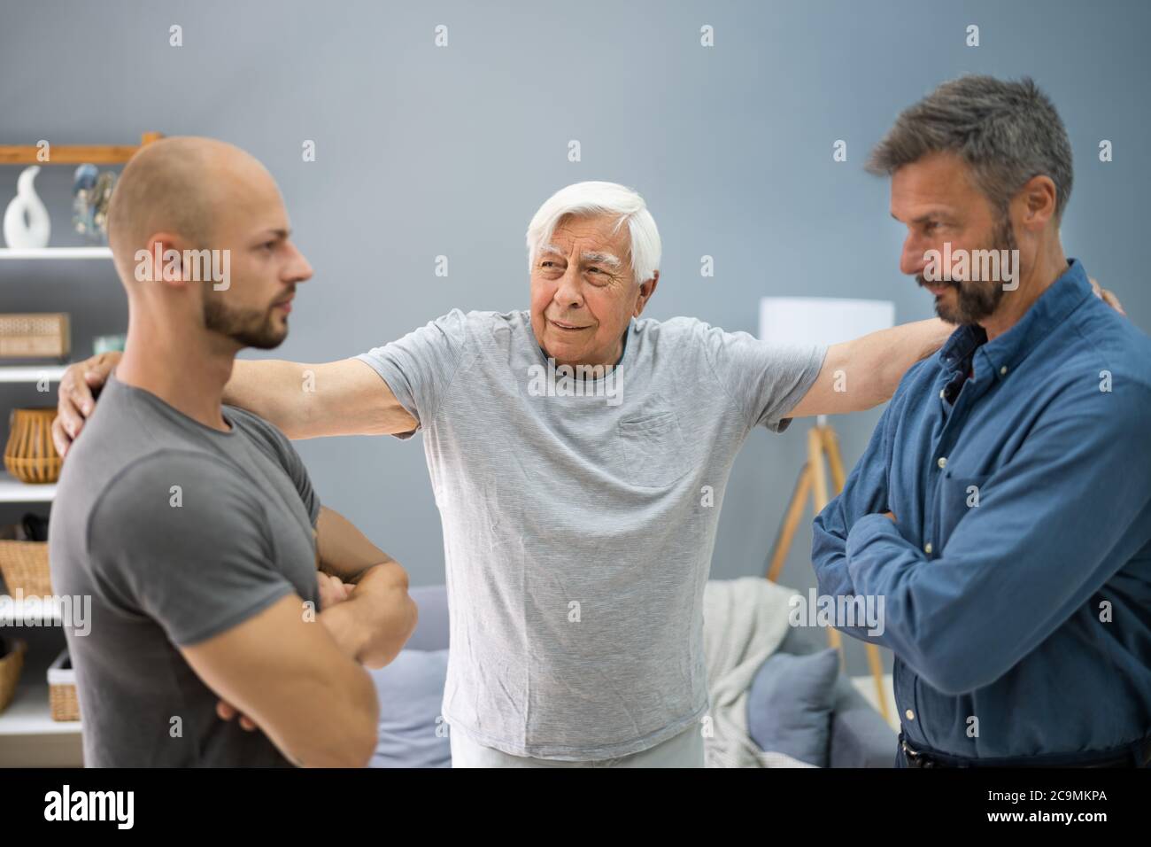 Grandfather Mediating In Father And Son Conflict Stock Photo
