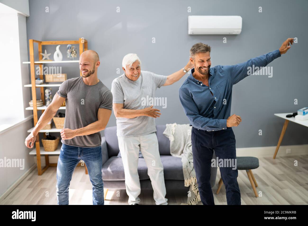 Three Generation Men Dancing And Exercising With Senior Grandpa Stock Photo