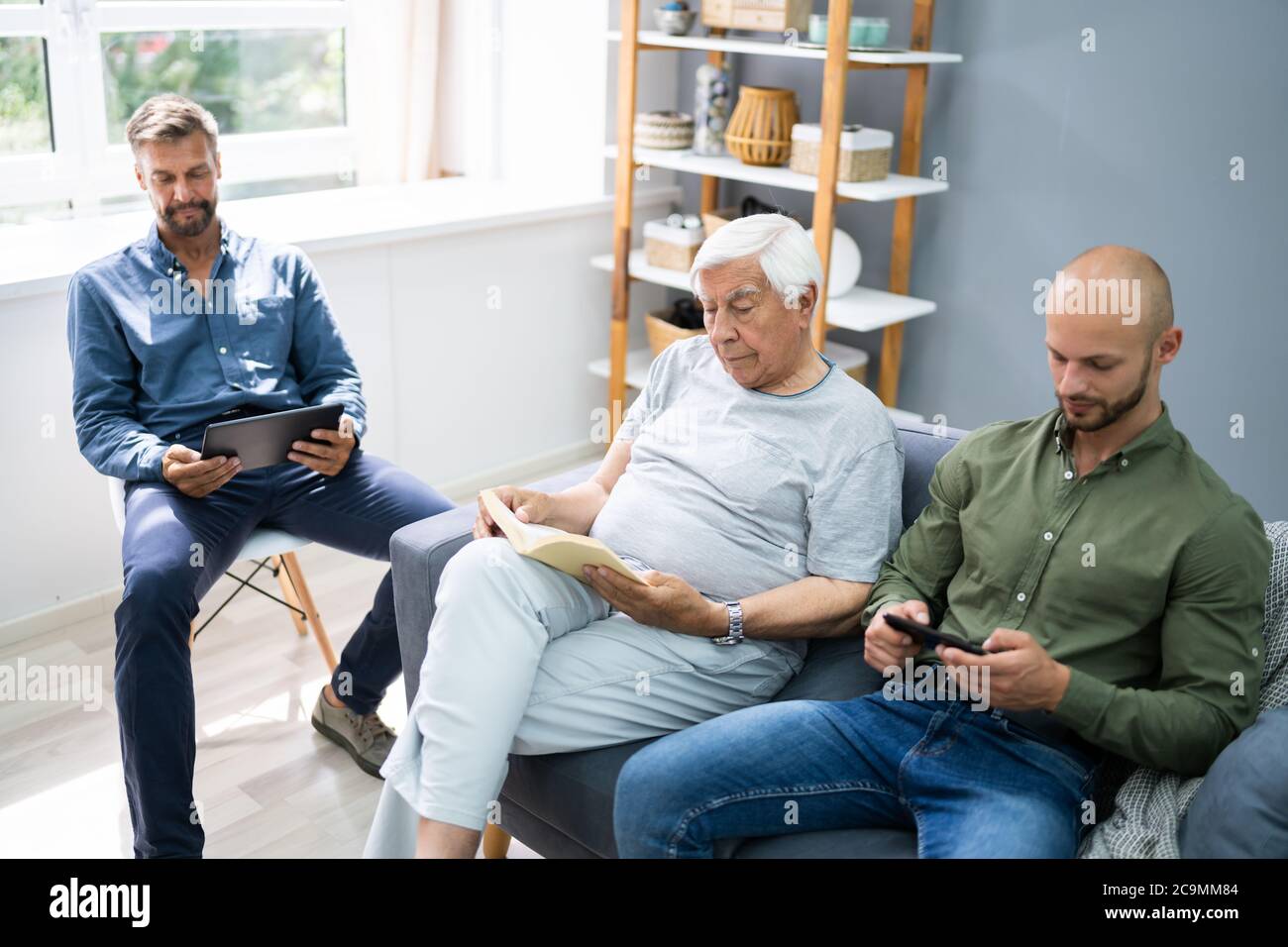 Three Generation Men Spending Time Together At Home Stock Photo