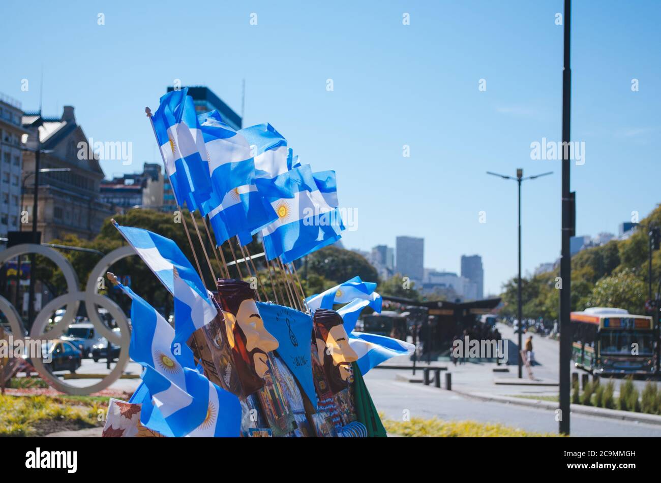 Buenos Aires, Argentina - September 4, 2018: Small argentinian flags for sale and flying over the wind along with masks of a famous national football Stock Photo