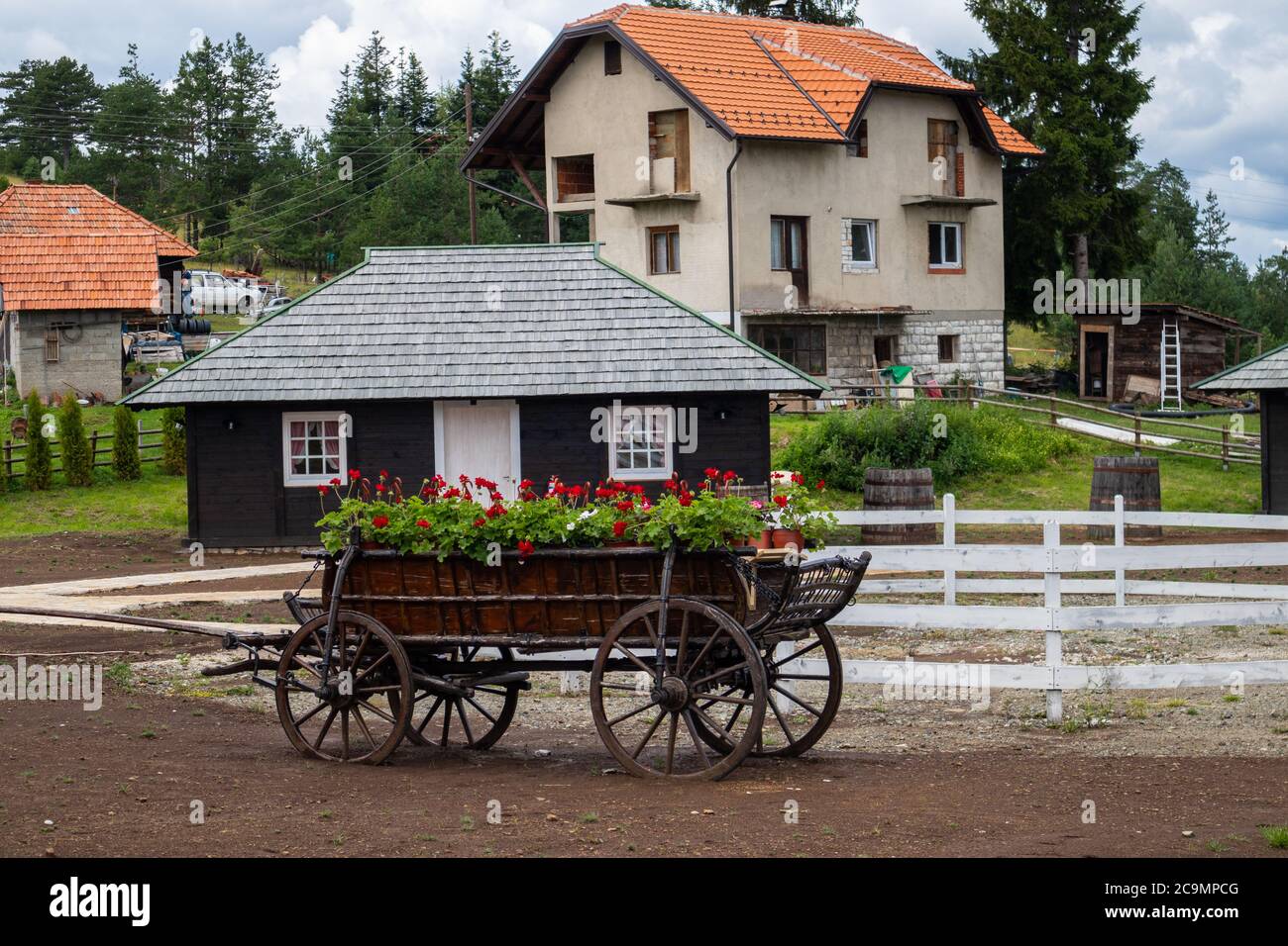 Zlatibor, Vodice, Serbia - July 26. 2020 Wooden wagon with flowers in the city of El Paso in old Serbian style. Serbian thematic park. Stock Photo
