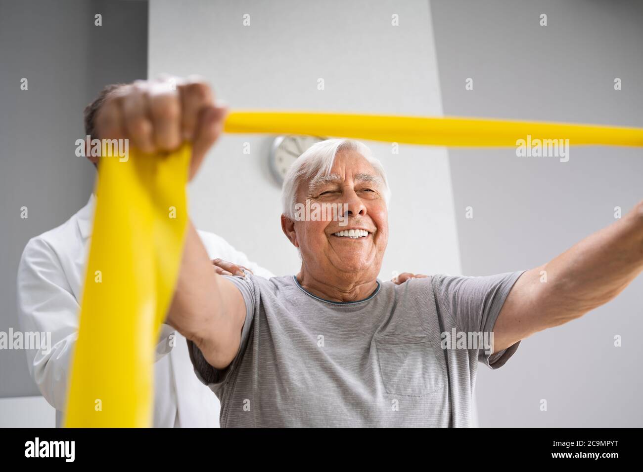 Physical Therapy Patient Using Physiotherapy Bands For Rehabilitation Stock Photo