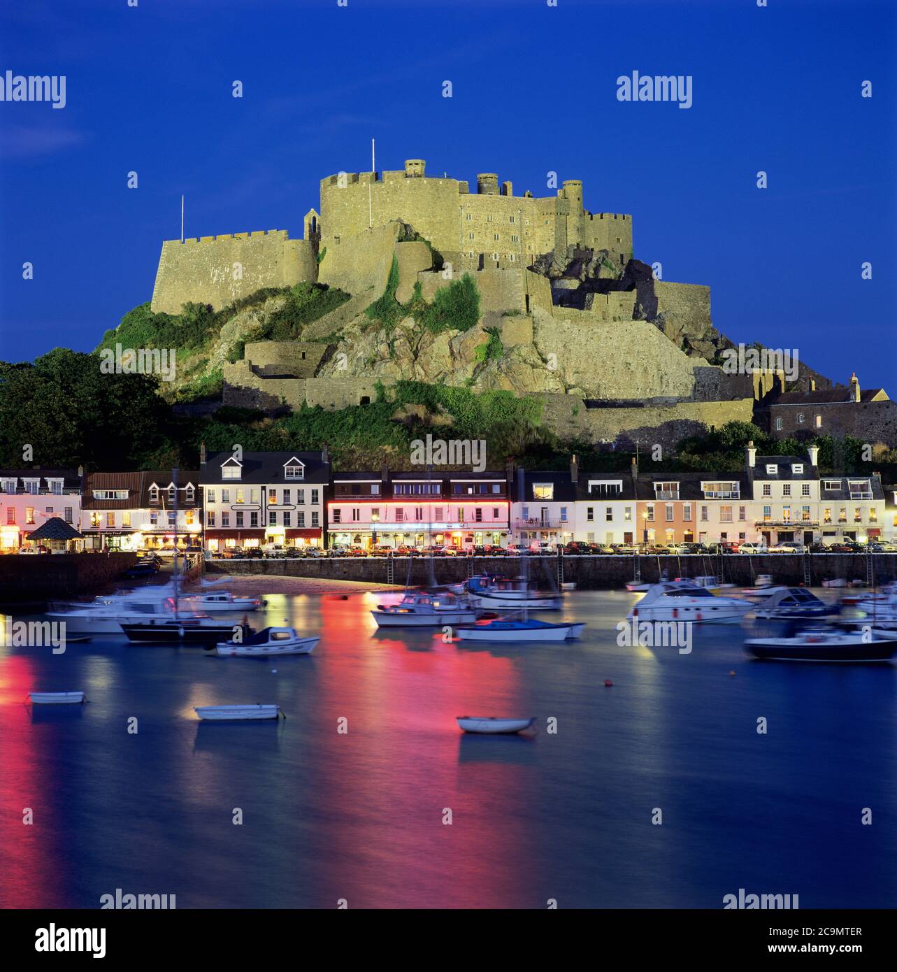 Mont Orgueil Castle overlooking the harbour and floodlit at night, Gorey, Jersey, UK Stock Photo