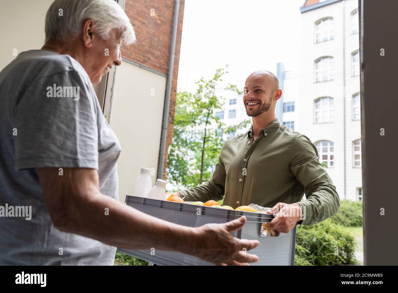 Grocery Food Shopping Help For Elder Senior Standing At Door Stock