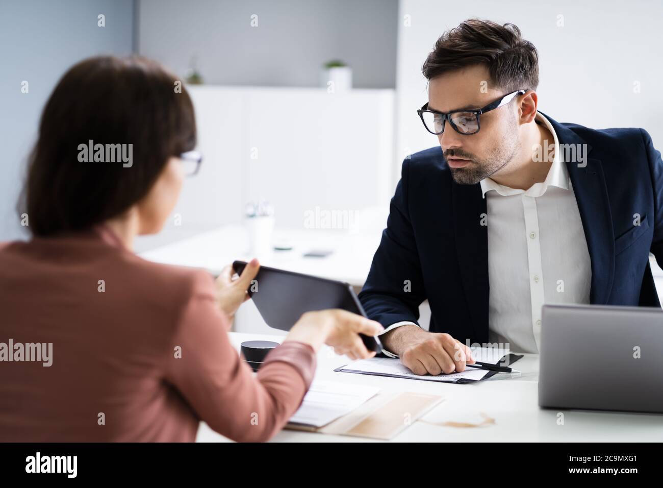 Financial Professionals At Business Meeting Using Digital Tablet Stock Photo