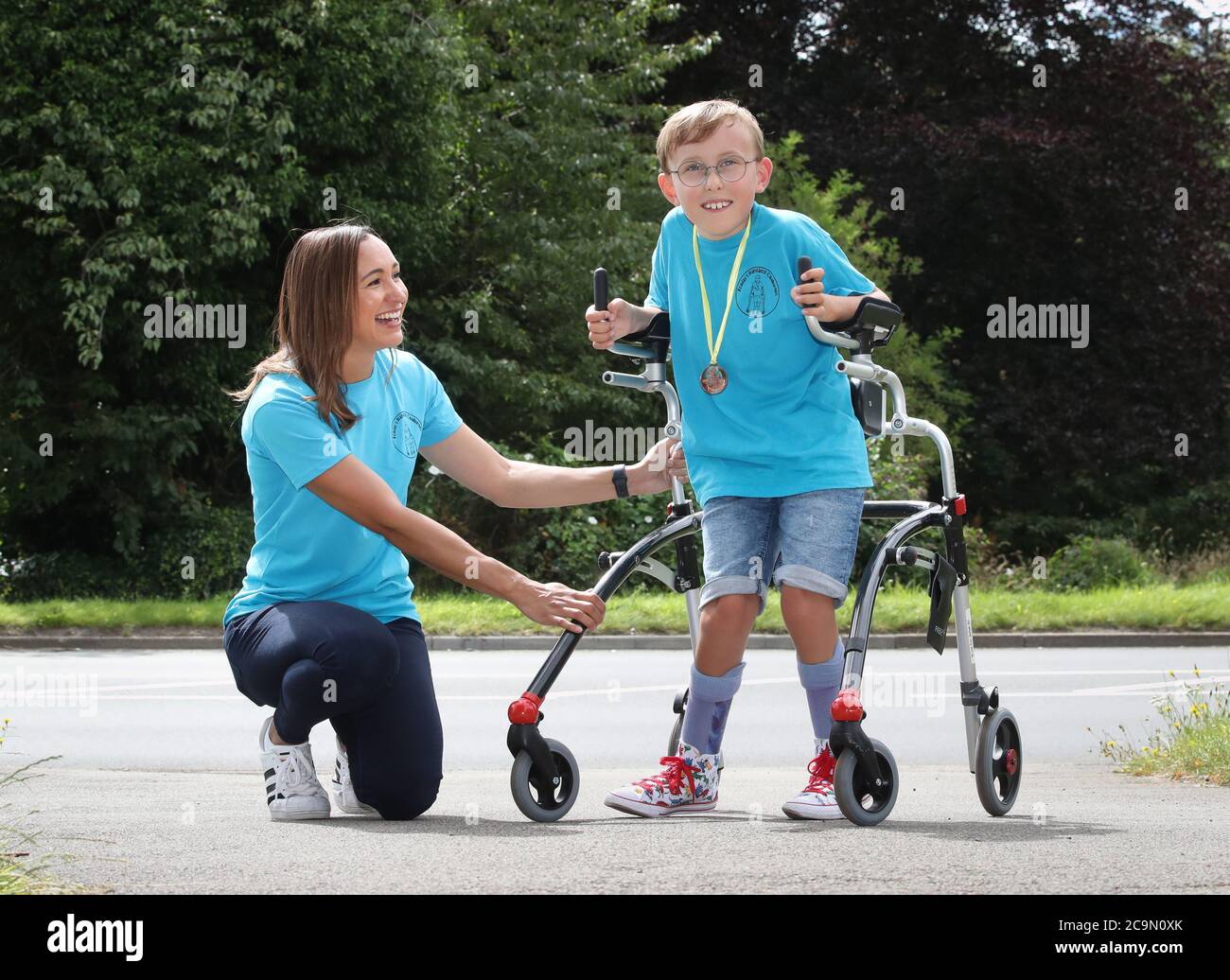 Tobias Weller, who has cerebral palsy and autism, alongside Olympic athlete Jessica Ennis-Hill (left), has completed his new challenge to run a marathon in a street near his home in Sheffield, using a race runner. Tobias, who cannot stand or walk unaided, was inspired by Captain Tom Moore to complete his first marathon on his daily walks back in April. Stock Photo