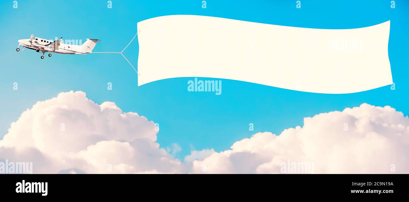 Airplane with white banner for advertising among the clouds. Tinted vintage style. Mockup for your text Stock Photo