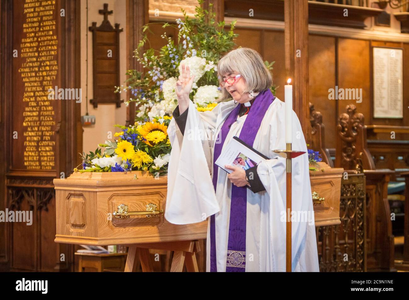 Female vicar officiating at a socially distanced funeral Stock Photo