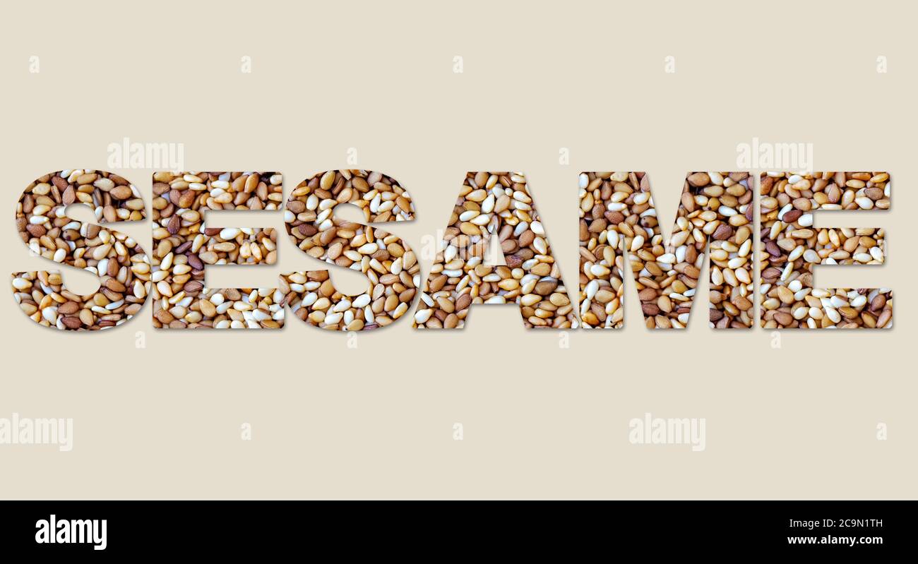 Word sesame from roasted seeds. Isolated on beige background Stock