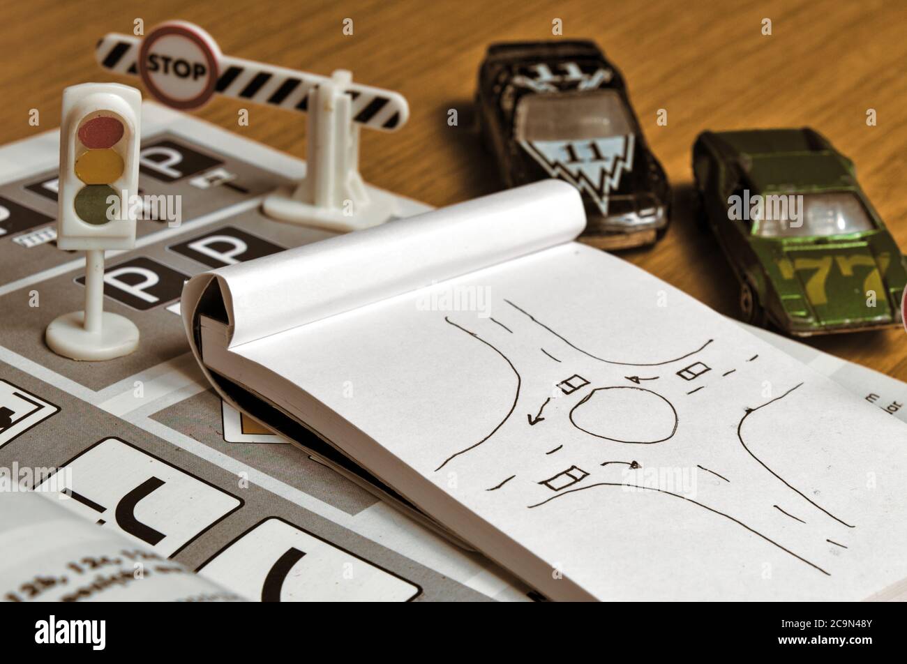 Notepad, book of traffic rules, toy cars, traffic lights and stop sign