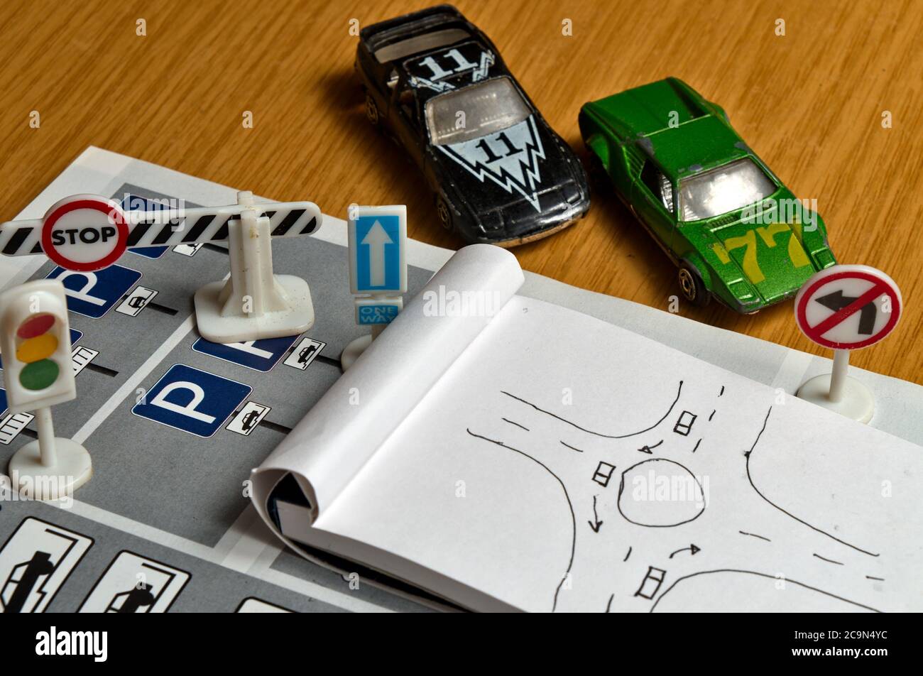 Notepad, book of traffic rules, toy cars, traffic lights and stop sign