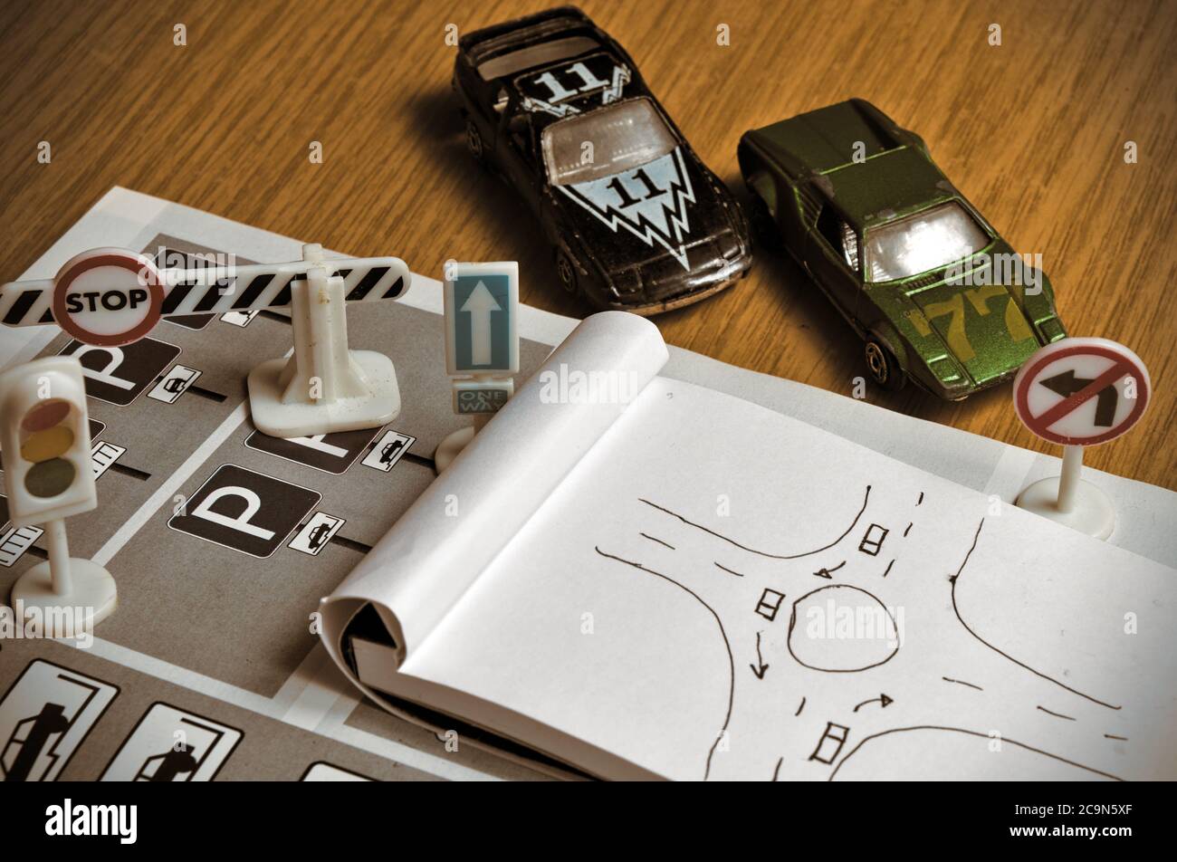 Notepad, book of traffic rules, toy cars, traffic lights and stop sign