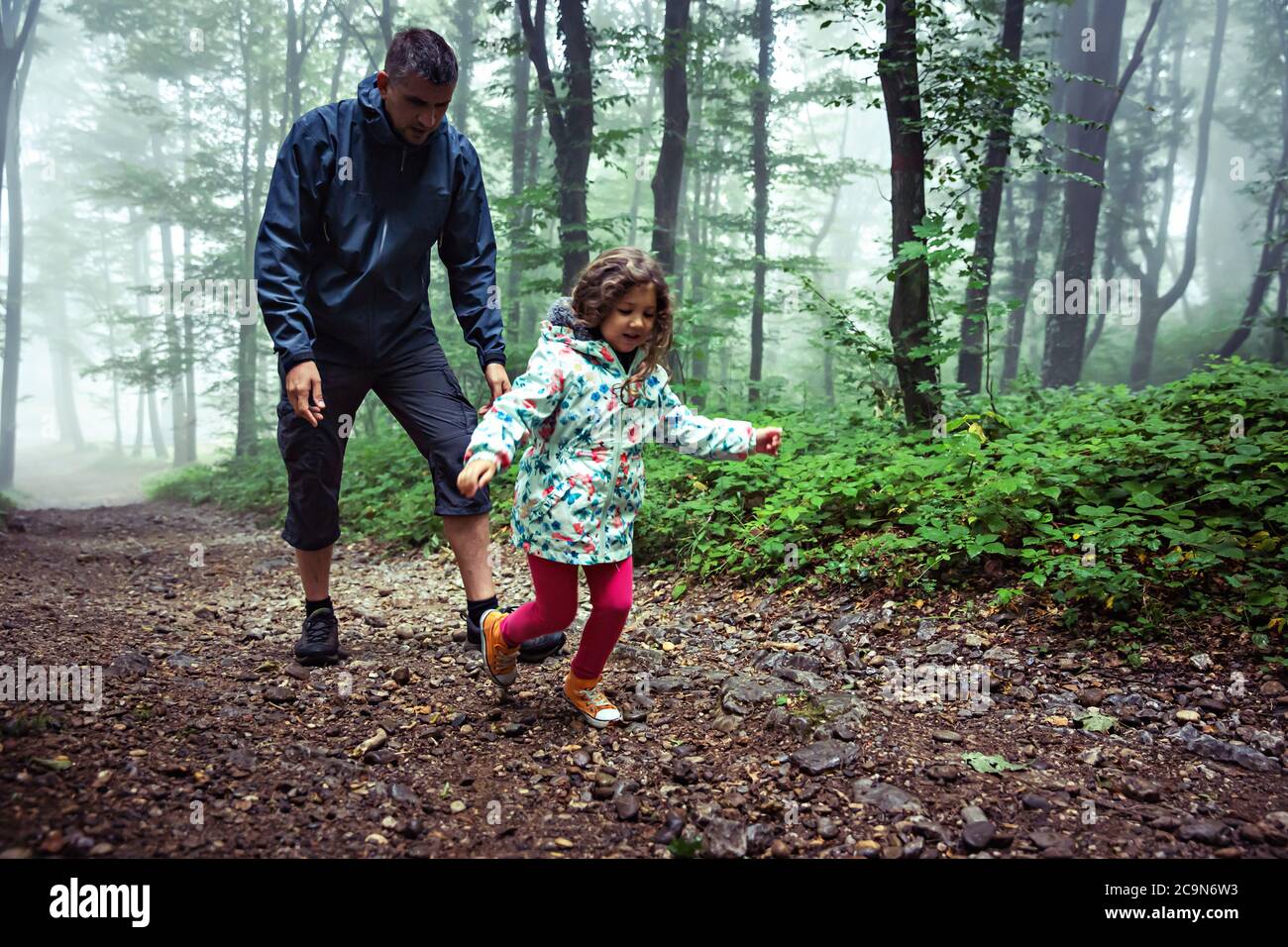 Father and his young daughter walking and playing forest landscape. Stock Photo