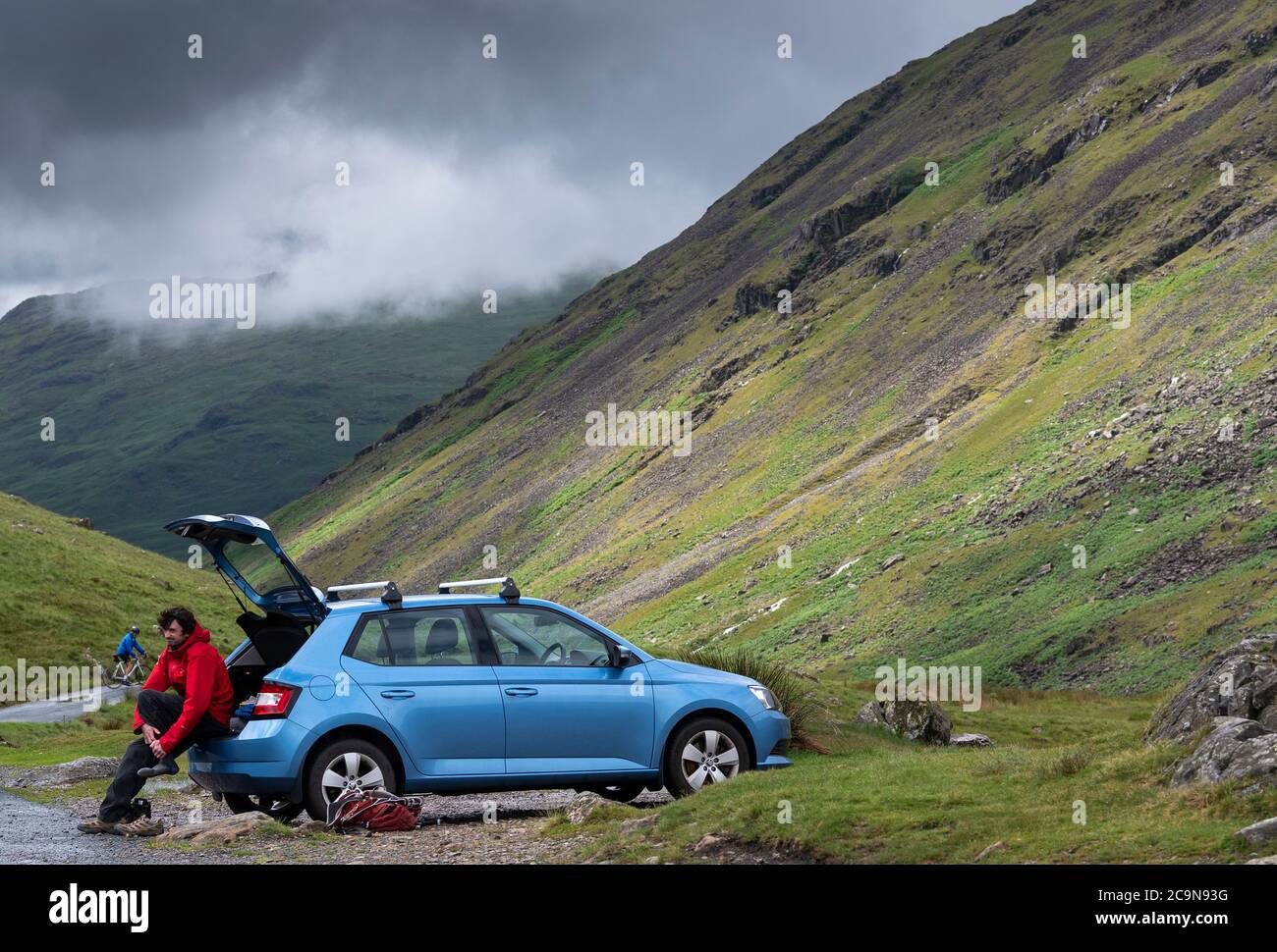 Hiker in the Lake District getting back to his car after a walk in the National Park. Wrynose Pass, Cumbria, UK. Stock Photo