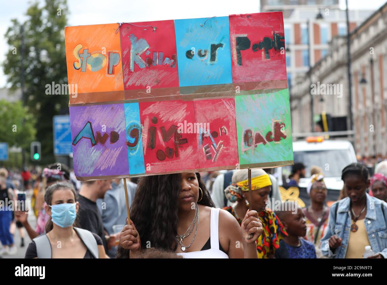 Protesters supporting the Stop the Maangamizi Campaign and the Afrikan Emancipation Day Reparations March Committee take part in a march from Windrush Square to Max Roach Park in Brixton, London. A curfew and other restrictions were imposed on demonstrations planned in south London to stop people blocking main roads or planning illegal music events, Scotland Yard has said. Stock Photo