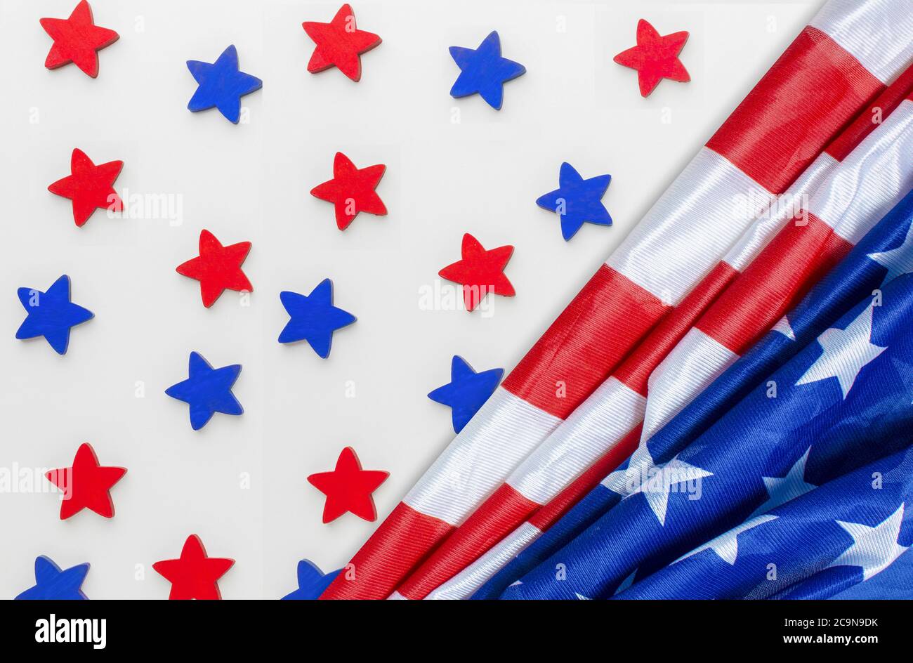 American flag placed on a white tabletop background and red,blue coloured stars are placed in