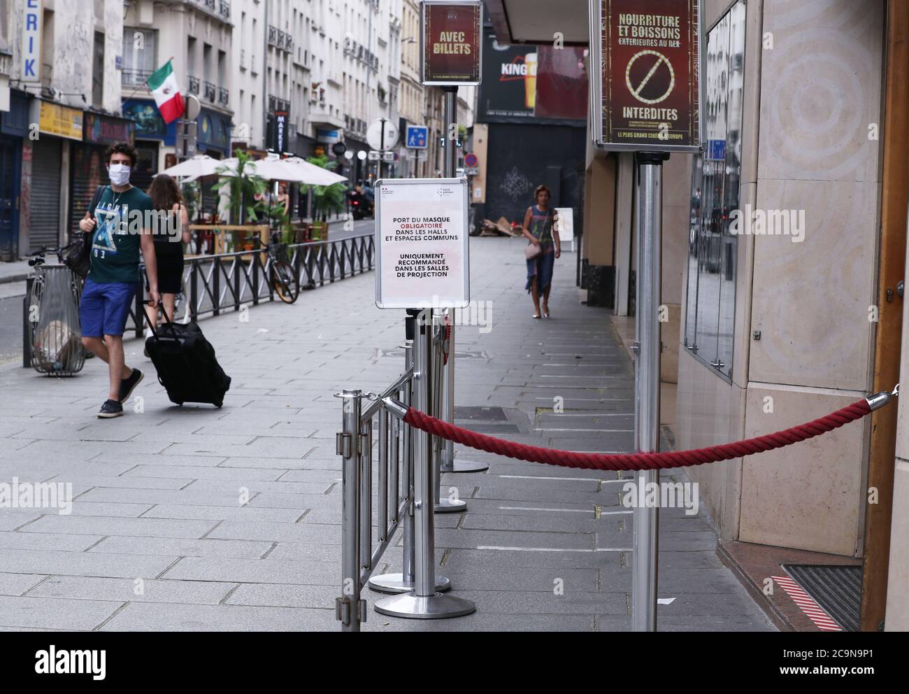 Paris, France. 31st July, 2020. People walk past the Grand Rex film theatre in Paris, France, July 31, 2020. Grand Rex, an iconic French cinema, will shut its doors for the month of August for the lack of audience and summer blockbusters. Credit: Gao Jing/Xinhua/Alamy Live News Stock Photo