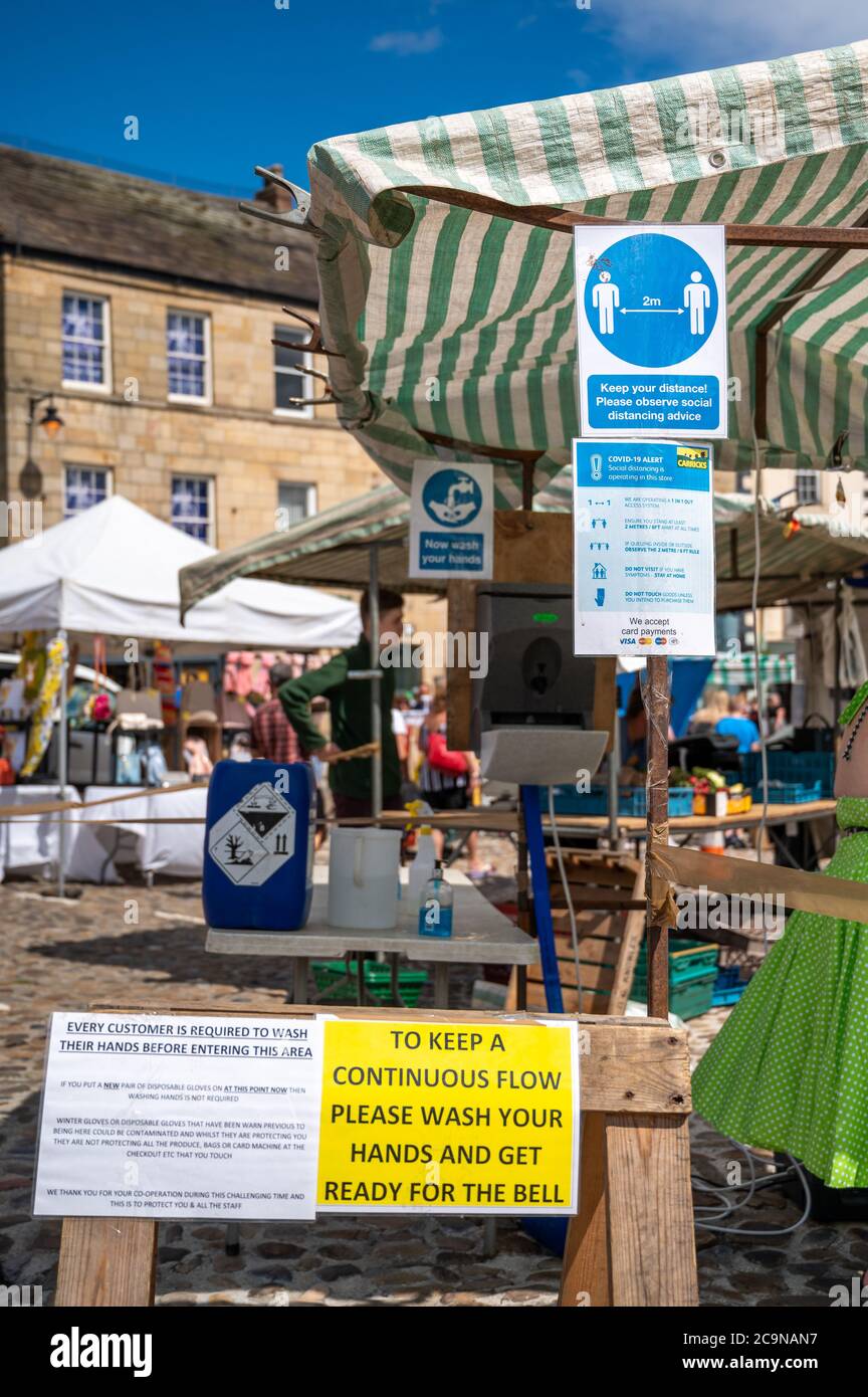 Richmond, North Yorkshire, UK - August 1, 2020: Covid 19 and social distancing signs at the entrance to a traditional outdoor market Stock Photo
