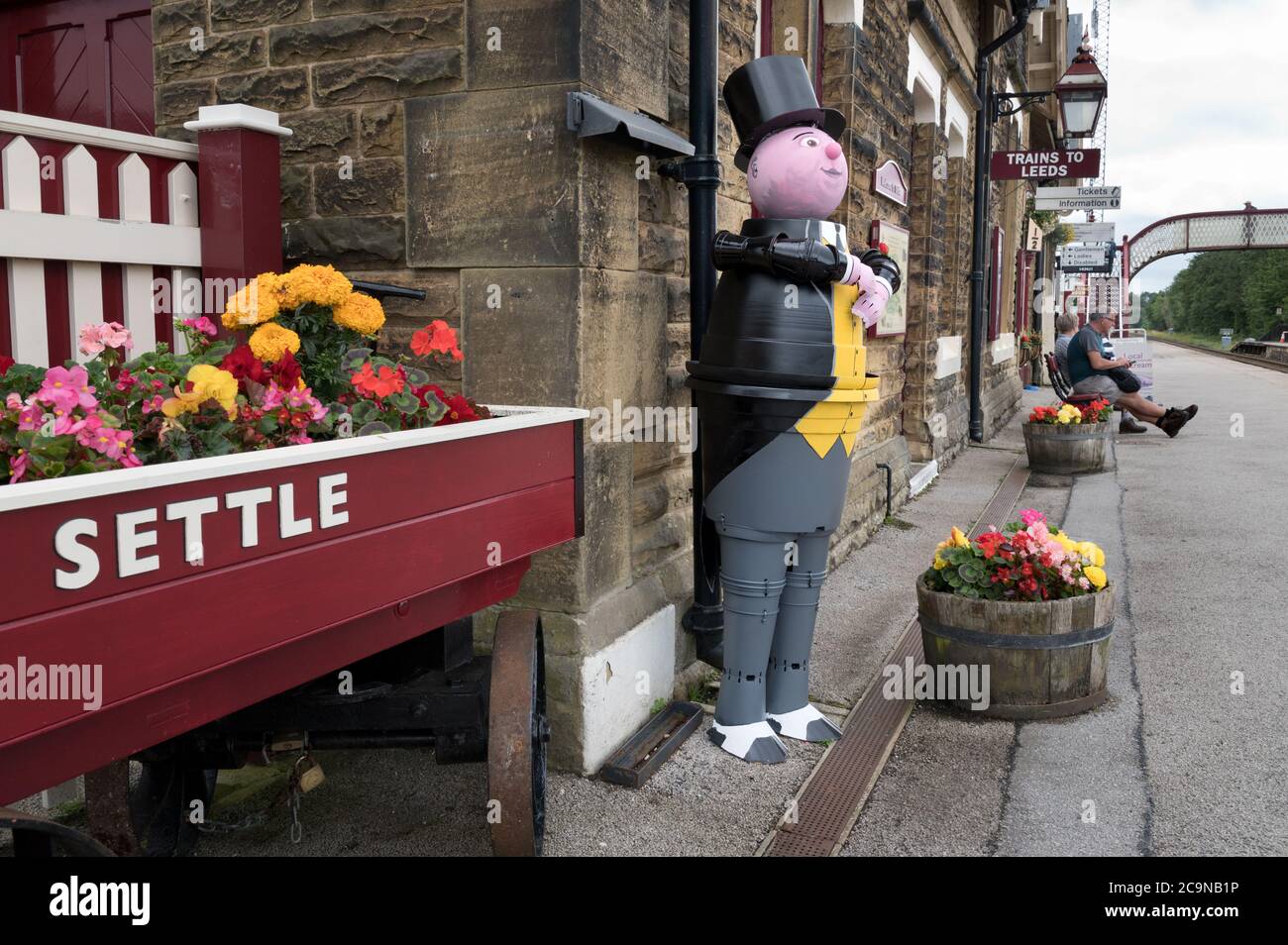 Settle, North Yorkshire, UK. August 1st 2020: The annual Flowerpot Festival opens in Settle, North Yorkshire, UK.  Topical flowerpot figures. made by local residents, appear all around the Yorkshire market town during August. Shown is The Fat Controller from the Thomas the Tank engine books, appropriately sited here on Settle station.This particular flowerpot figure was made by local resident Richard Handscombe. Credit: John Bentley/Alamy Live News Stock Photo
