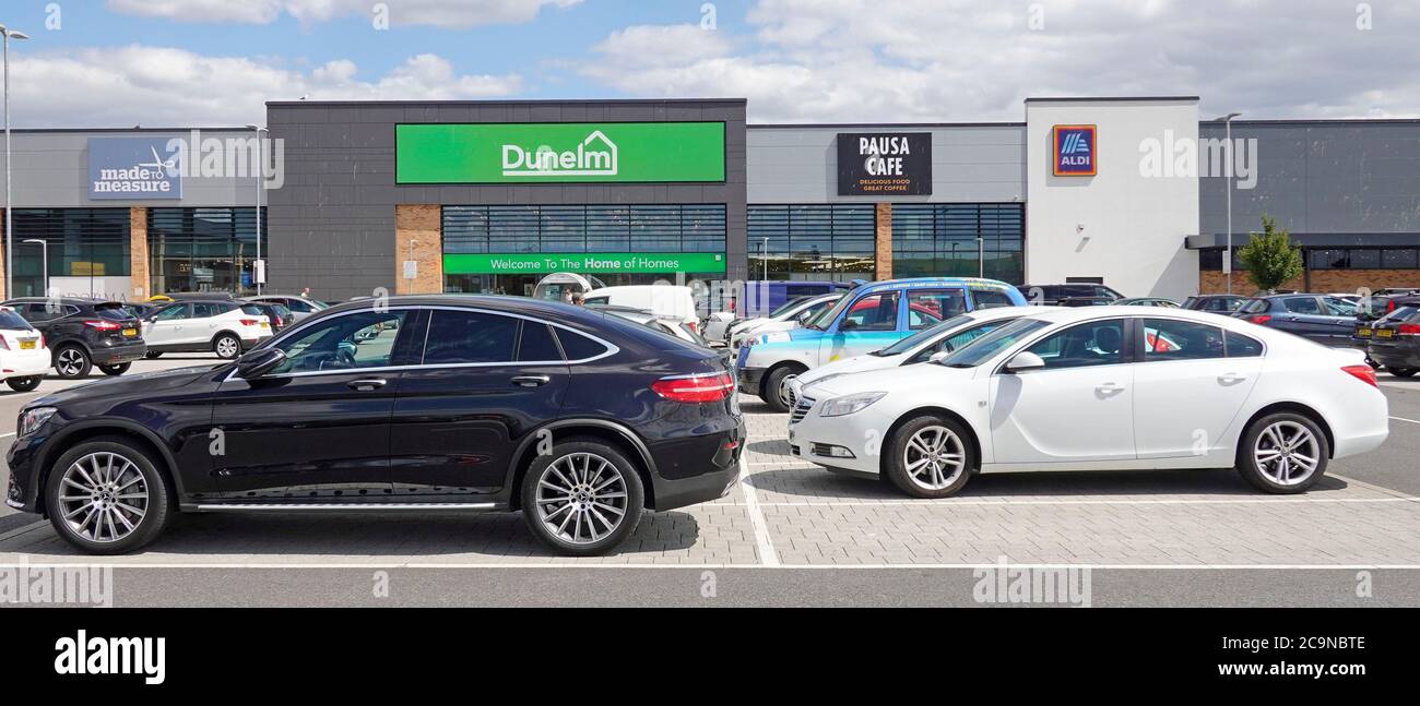 Free car park in Clock Tower Retail Park outside stores Made to Measure Dunelm Pausa Cafe & Aldi supermarket shop front beyond Chelmsford Essex UK Stock Photo