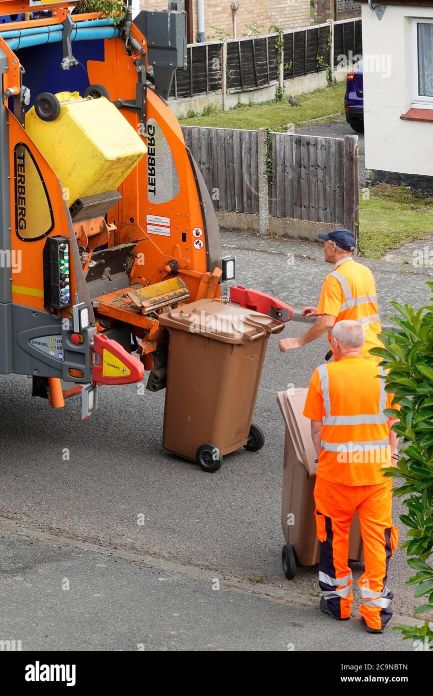 Council dustman workers & back of rubbish bin collection dustcart lorry truck dustmen collect green household garden waste wheelie bins recycling UK Stock Photo