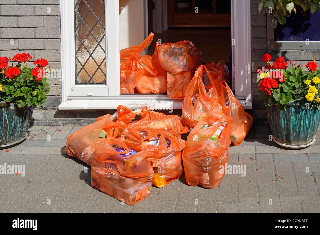 Sainsburys Covid 19 grocery food shopping bag left by delivery van driver bags moved later by customer into house & maintains social distance rules UK Stock Photo
