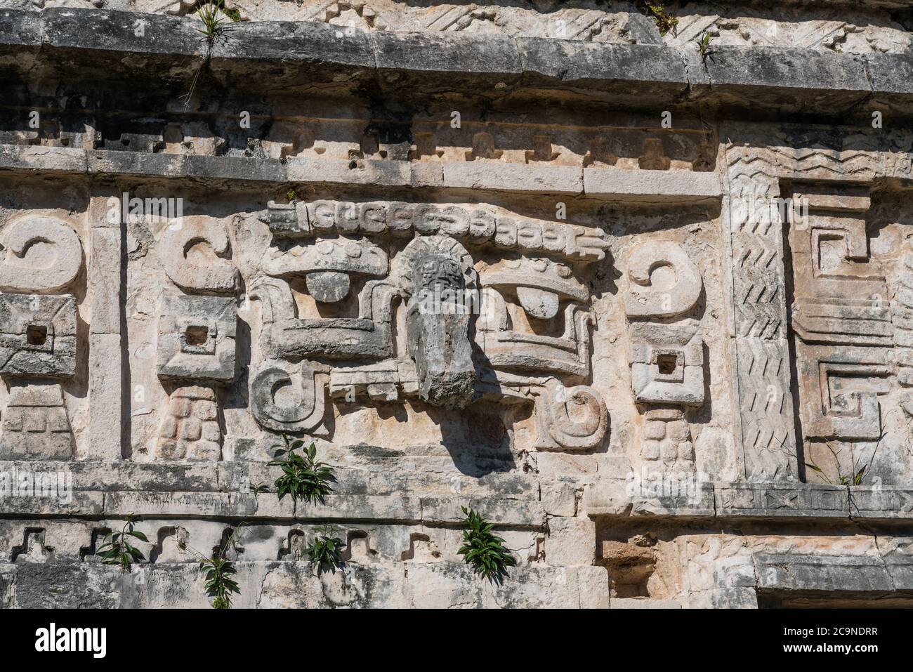 A stone carved Chaac mask on the facade of the Nunnery Complex in the ruins of the great Mayan city of Chichen Itza, Yucatan, Mexico. Stock Photo