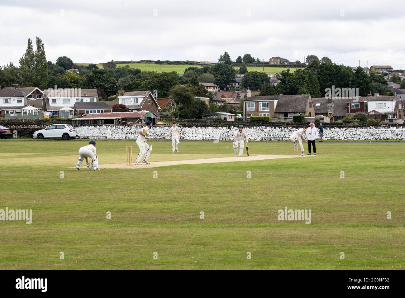 View of a Saturday afternoon village cricket match taking place in Kirkheaton Village in West Yorkshire, England U.K. Stock Photo