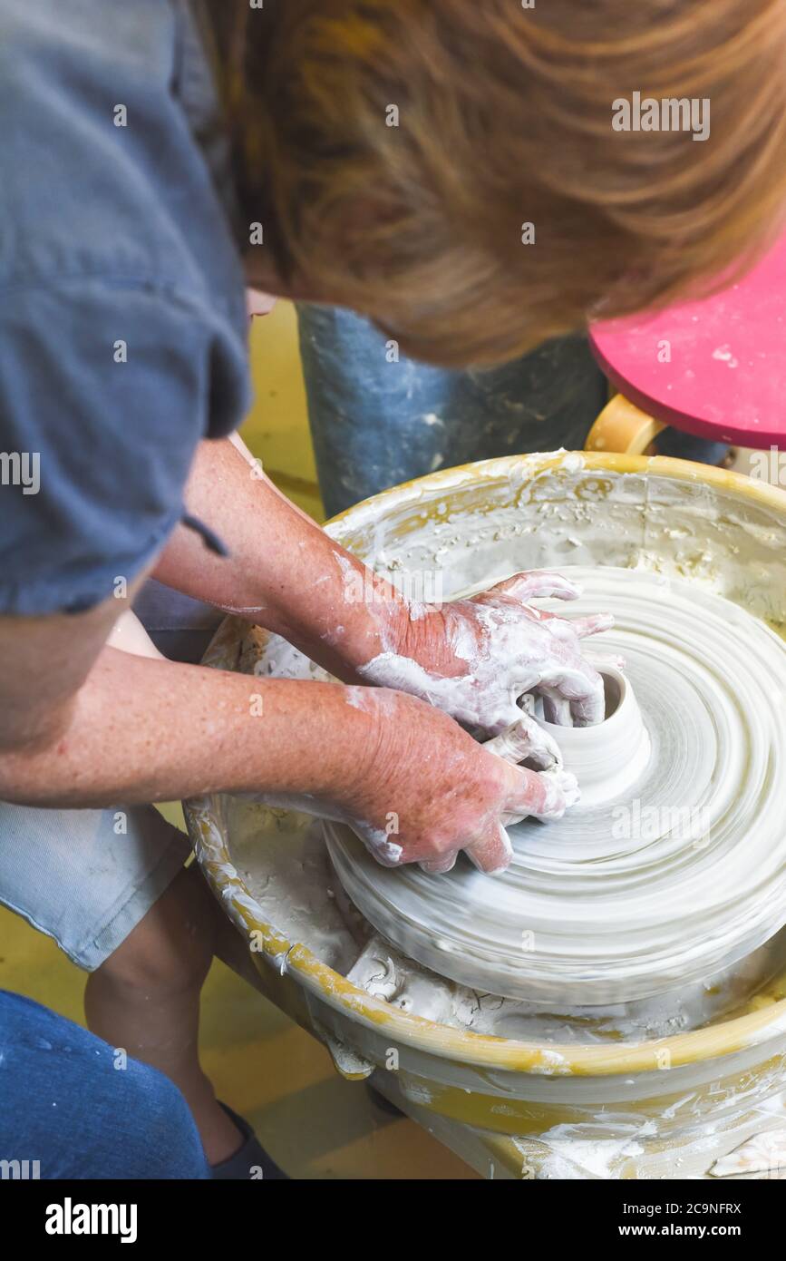 Children learning to make pottery as a hobby with their grandmother in
