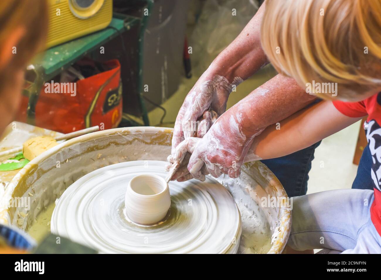 Children learning to make pottery as a hobby with their grandmother in