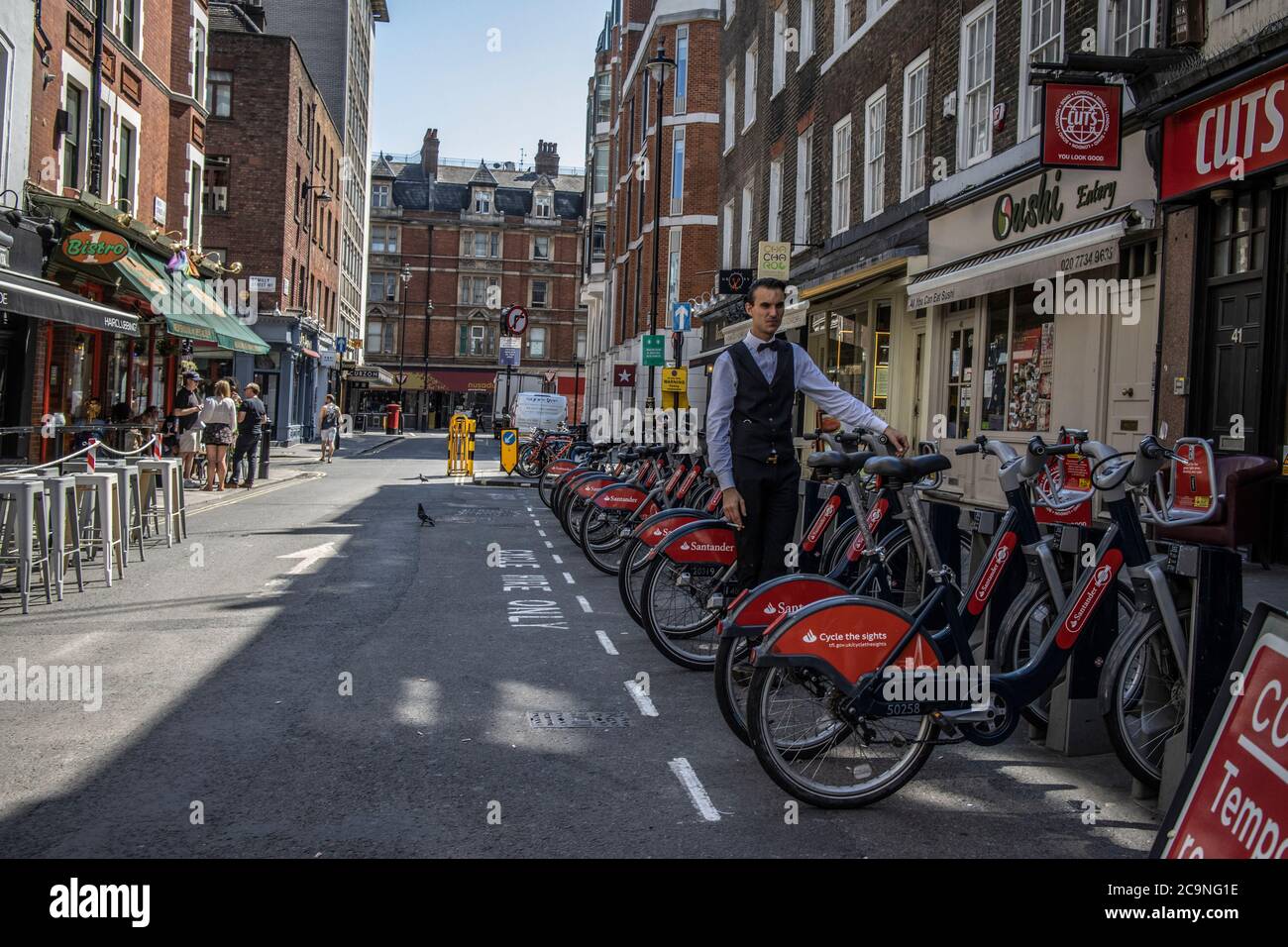 Restaurant waiter taking break on Frith Street in Soho during a warm summers afternoon, London, England Stock Photo