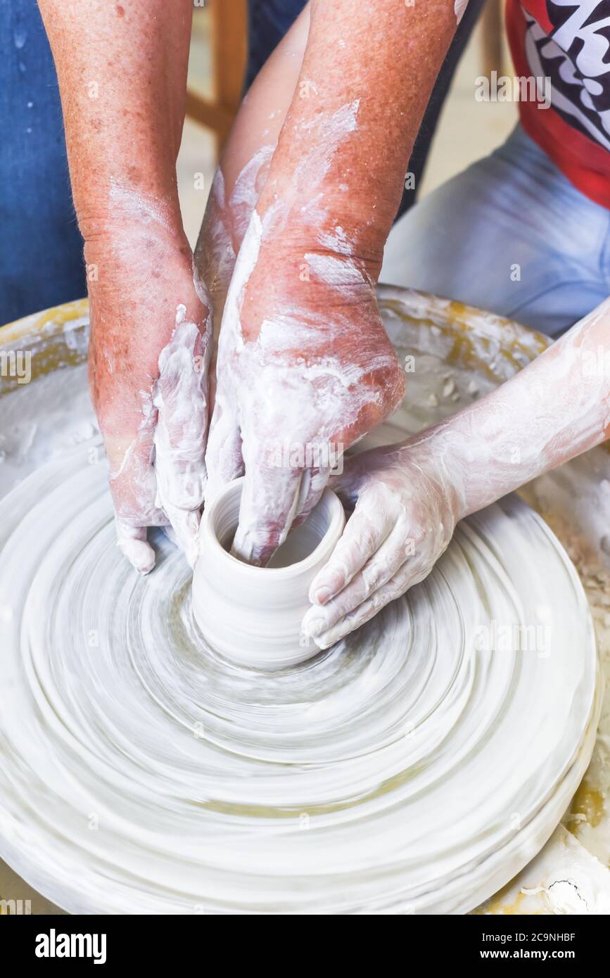 Children learning to make pottery as a hobby with their grandmother in