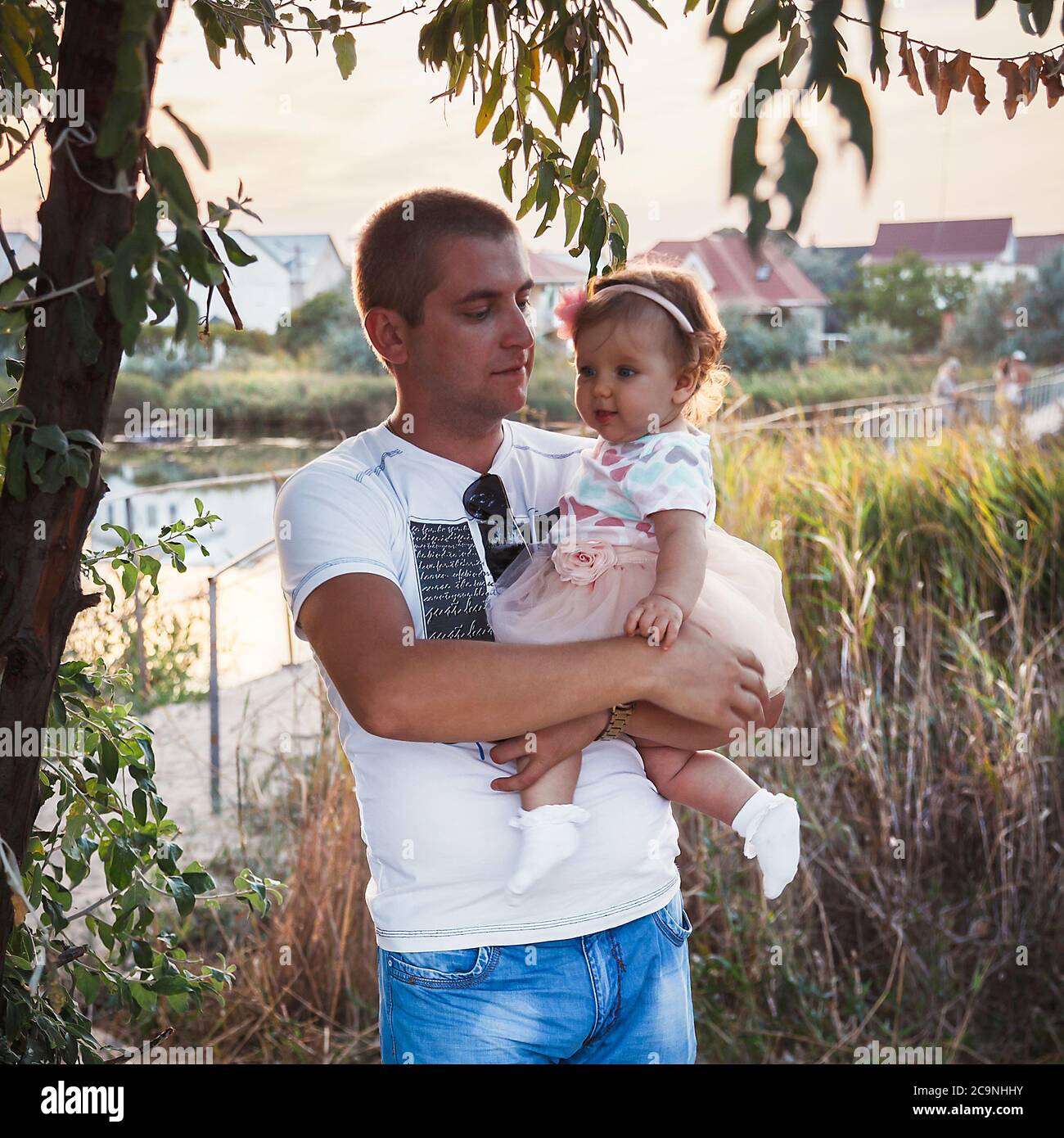 ODESSA, UKRAINE - SEPTEMBER 02, 2014: Young father holding his baby girl outside in the park Stock Photo