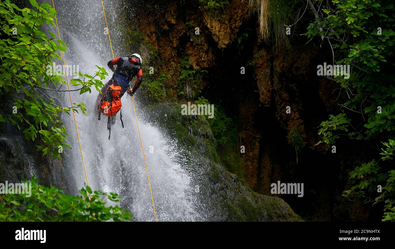 Hombre bajando cascada de agua Stock Photo
