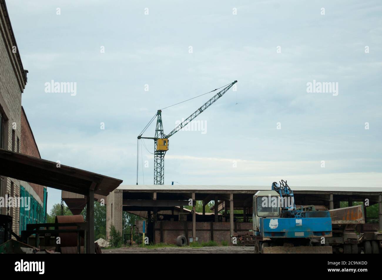 View of obsolete working machines at a small rural working brick factory. Dirty, old transport on a background of the sky, nostalgia. In a parking Stock Photo