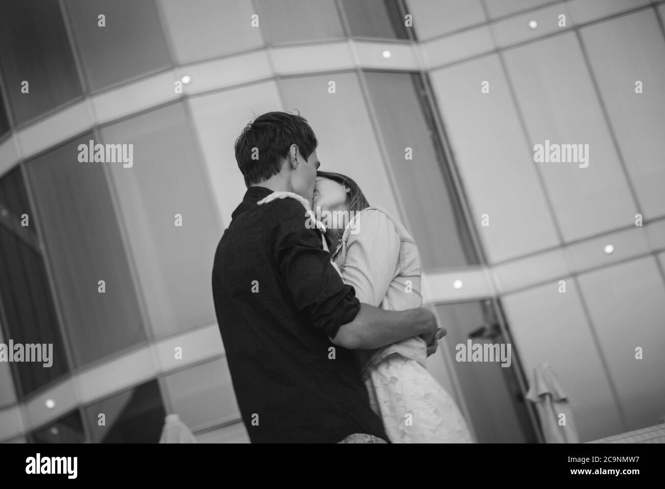 Hugging and kissing couple, at sunrise sky summer time in city, urban background Stock Photo