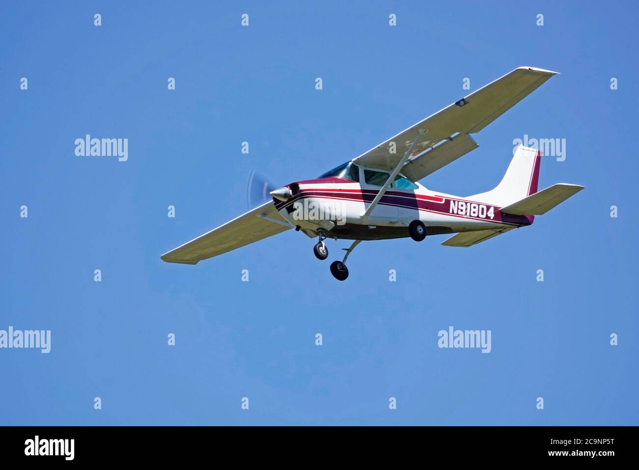 A small, single wing, single engine Cessna aircraft in a landing pattern over a small airport in Oregon. Stock Photo