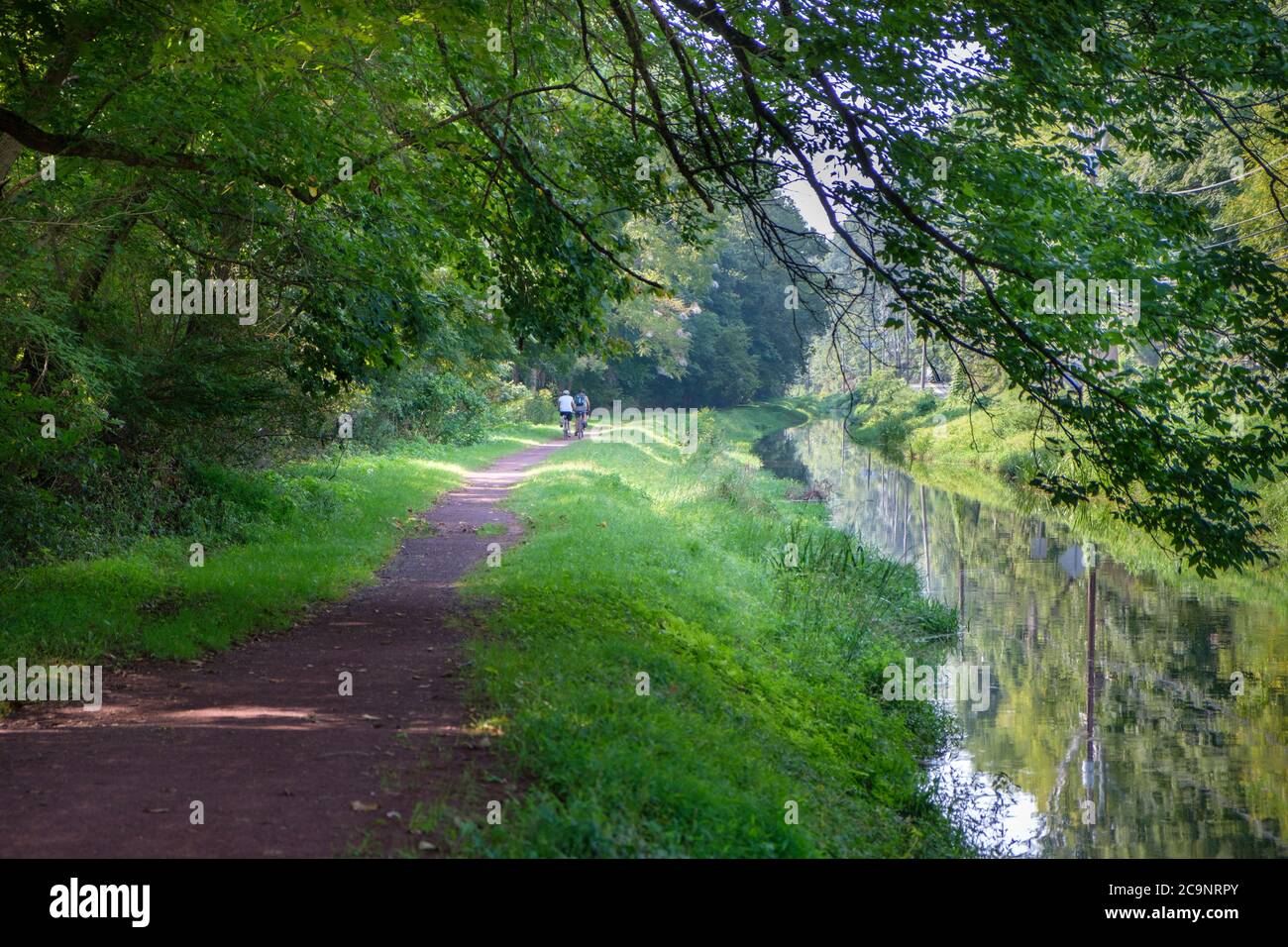 The tow path trail by the Delaware Canal and Delaware River with cyclist, Bucks County, New Hope, Pennsylvania, USA Stock Photo