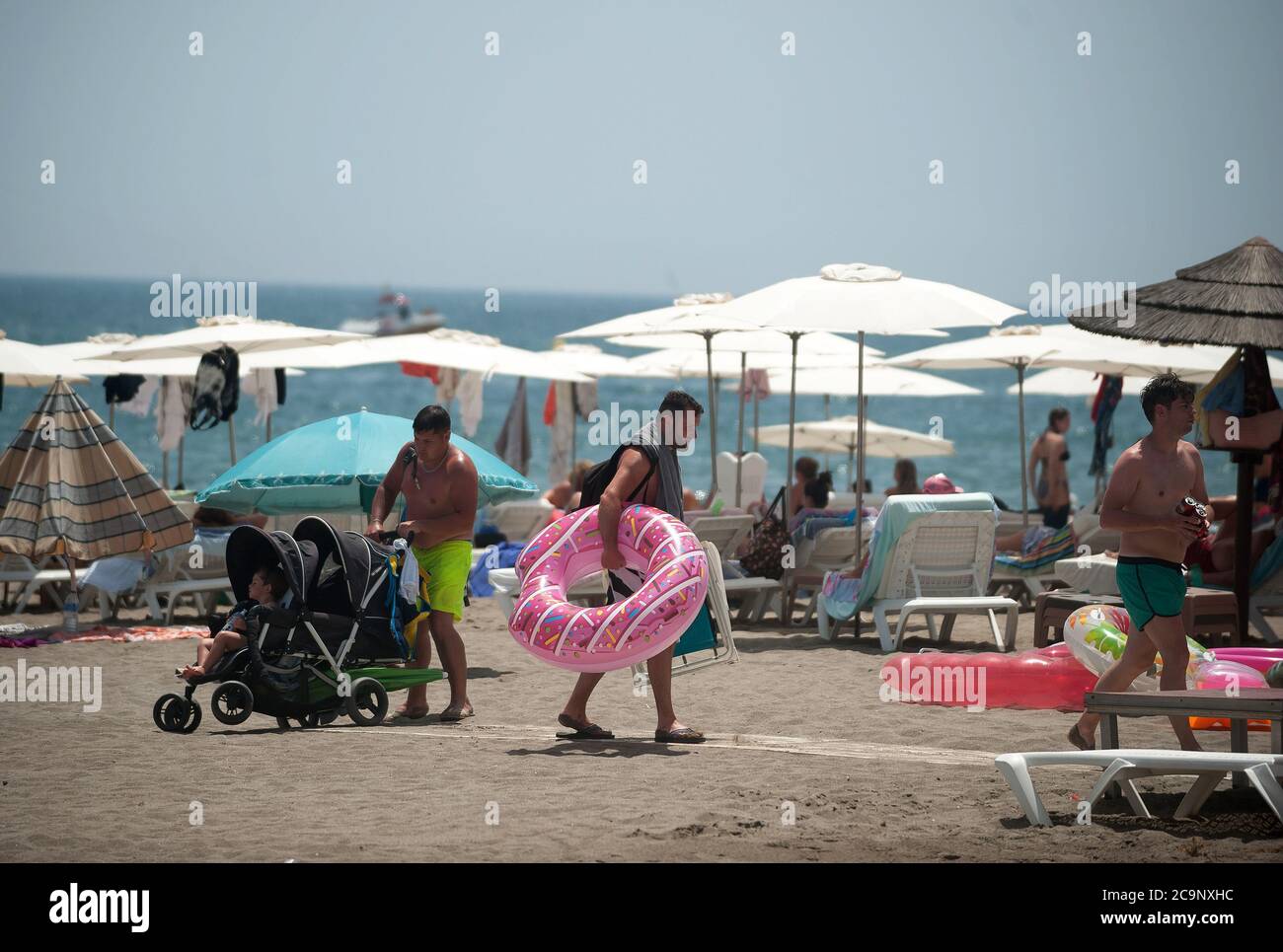 Malaga, Spain. 1st Aug, 2020. A man carrying a pink float as he leaves Rincon Sol beach of Torremolinos during a hot summer day.The first heavy heat wave hits the country with high temperatures. In Andalusia, according to the Spanish Meteorology Agency, majority of the cities are in orange warning with temperatures over 40 degrees Celsius during the weekend. Credit: Jesus Merida/SOPA Images/ZUMA Wire/Alamy Live News Stock Photo