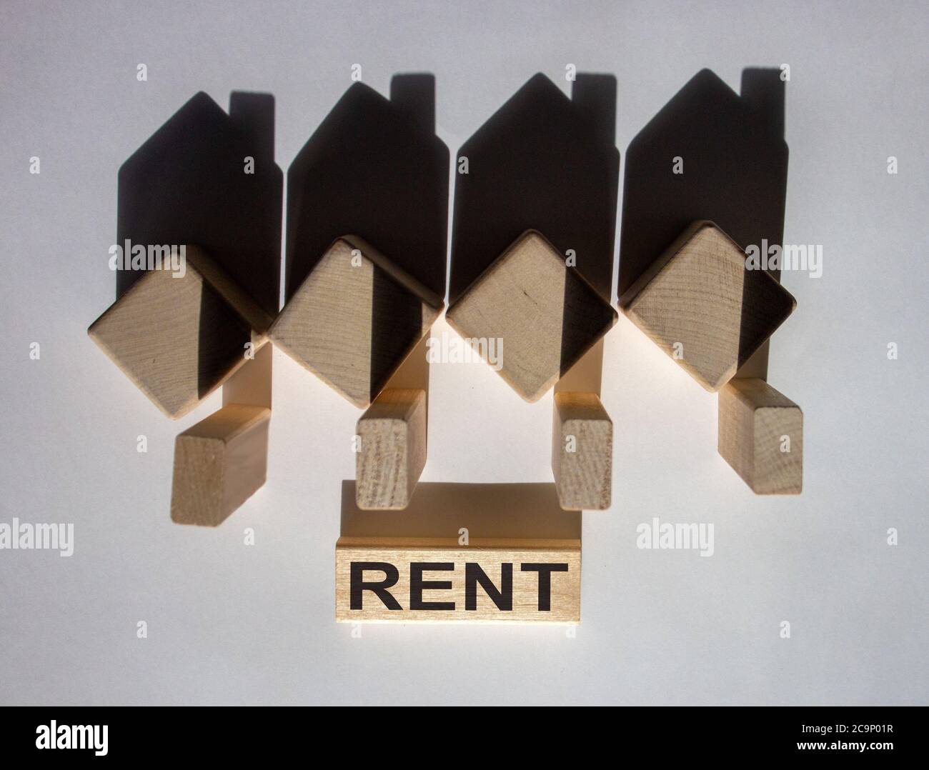 Houses created by shadows from wooden cubes. The word 'rent' on a ...