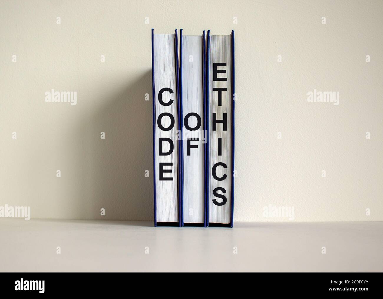 Books with text 'code of ethics' on beautiful white background. Business concept. Copy space. Stock Photo