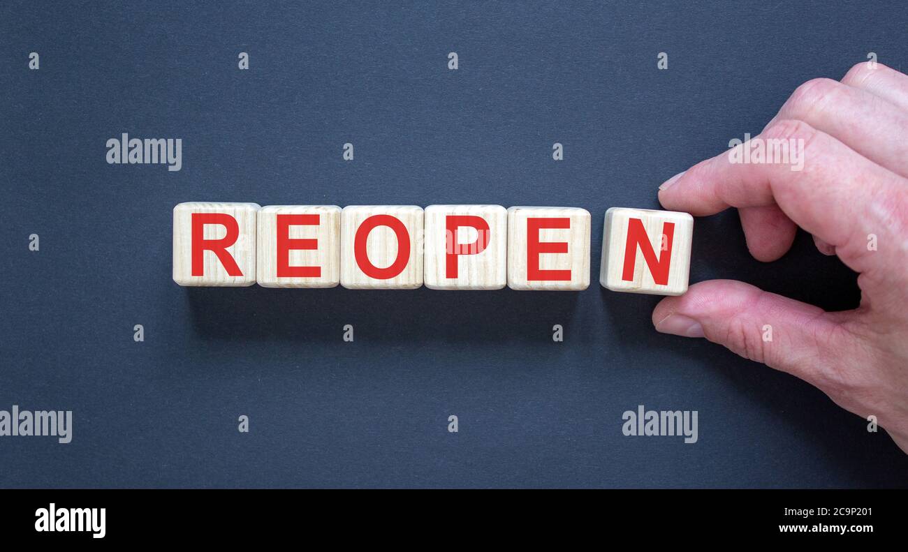 Wood cubes with word 'reopen' on paper black background, copy space ...