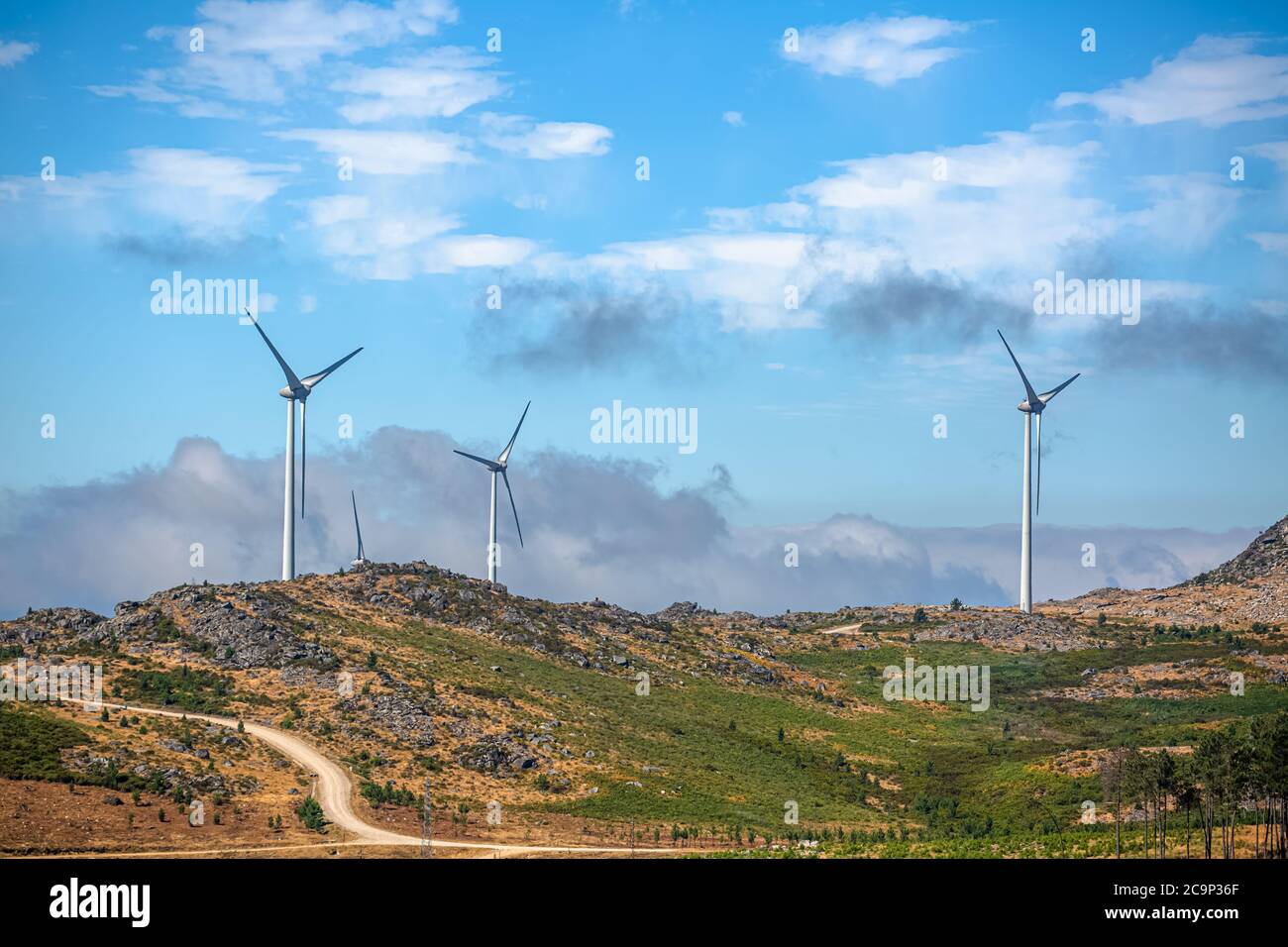 View of a wind turbines on top of mountains, cloudy sky as background ...