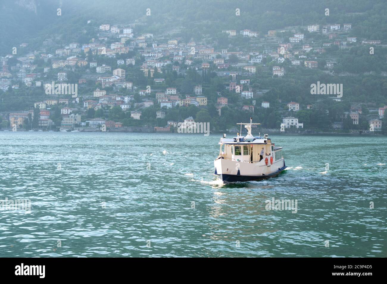 Ferry boat in the Lake Como (Lago di Como) in front of the Torno, small village in Lecco, Italy, Europe Stock Photo