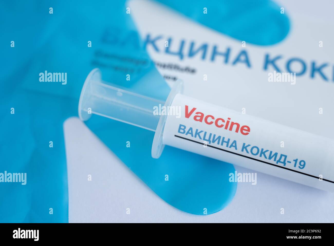 syringe with covid-19 vaccine in russian language and blue gloves in the background, Denmark, August 1, 2020 Stock Photo