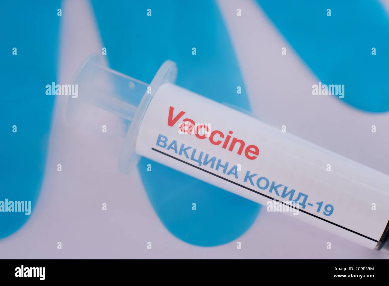 syringe with covid-19 vaccine in russian language and blue gloves in the background, Denmark, August 1, 2020 Stock Photo