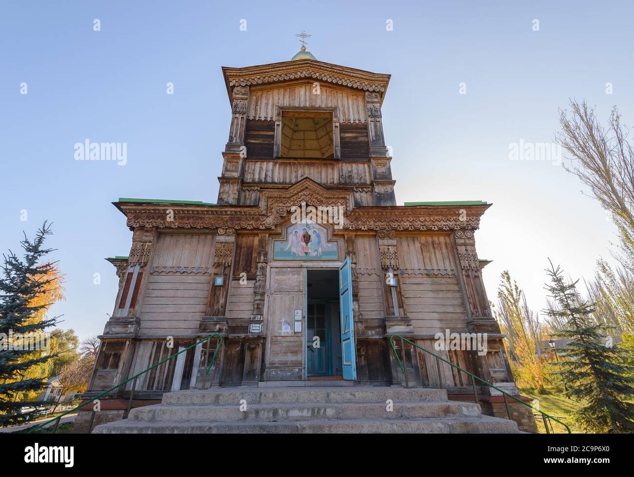Main entrance of Holy Trinity Orthodox Church in Karakol, Kyrgyzstan. Wooden Cathedral with facade decorated with carvings. Stock Photo