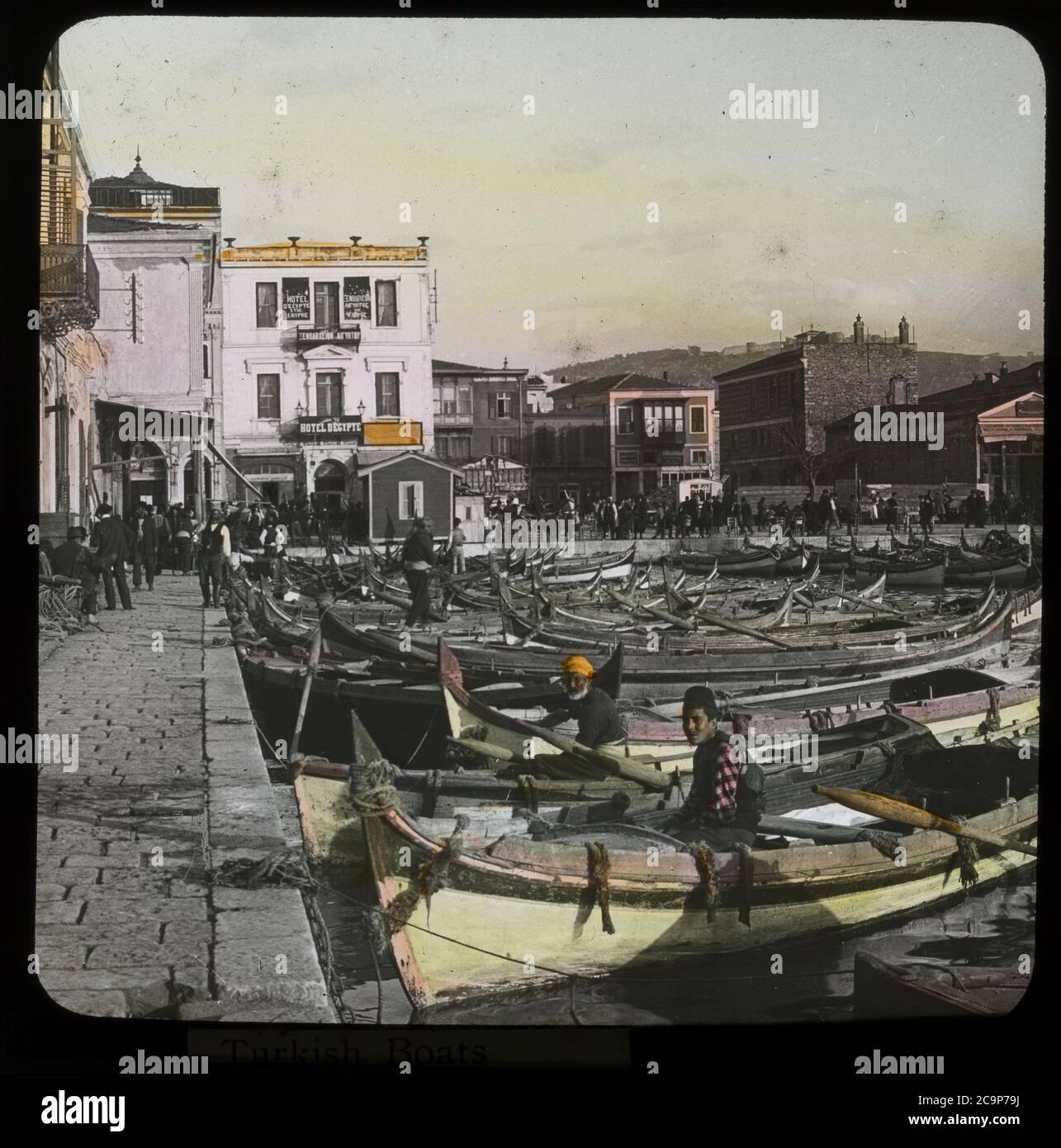 Port of Smyrna / Izmir, Turkey with docked rowboats. Hotel d'Egypte at the end of the mole. Hand-colored photograph on dry glass plate from the Herry W. Schaefer collection, around 1910. Stock Photo